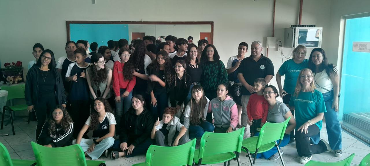 foto com todas as pessoas presentes: todos meio embolados, na frente do salão, na frente do espelho, há cerca de 30 e poucas crianças, eu, 3 bibliotecárias e alguns funcionários da prefeitura. 